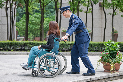 車椅子利用者をサポートする警備員
