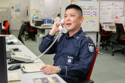 防災センターで電話対応する警備員